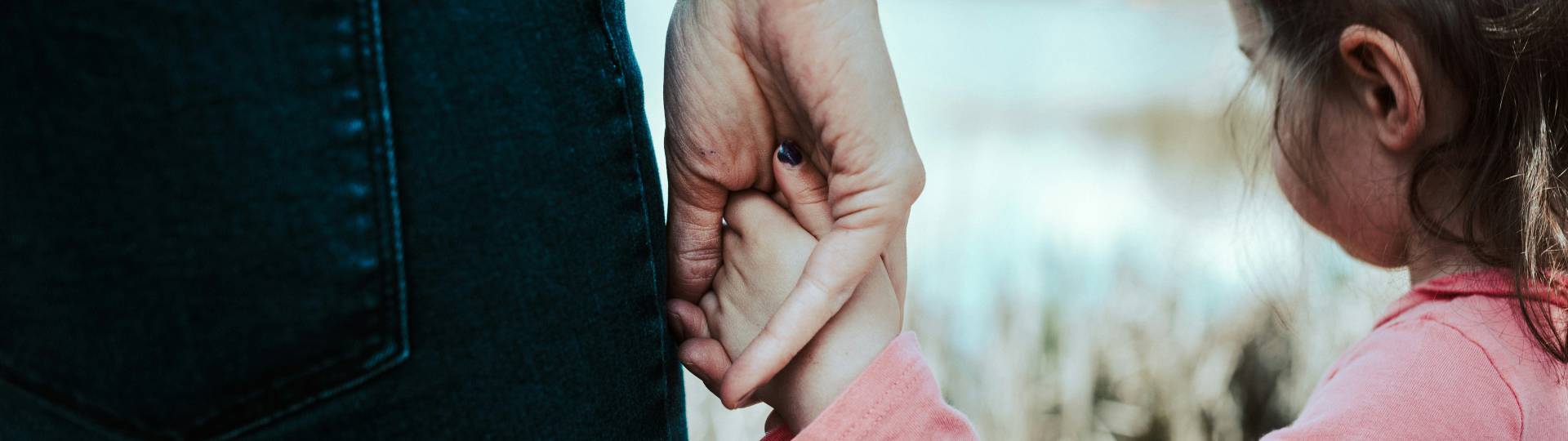 Petite fille tenant la main d’un adulte